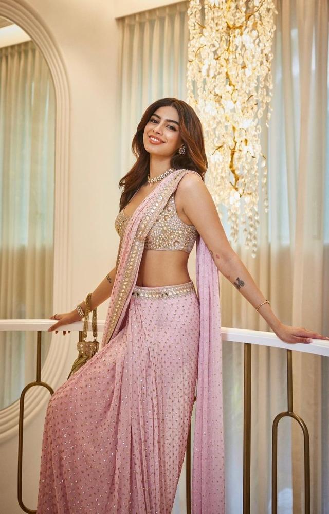 Khushi Kapoor stunned in a custom mirror sequin and pastel thread pink saree at Aaliyah Kashyap`s engagement. She added a touch of glam with a Potli bag 